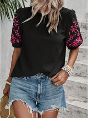 Black embroidered puff sleeve blouse with pink floral detail on sleeves.
