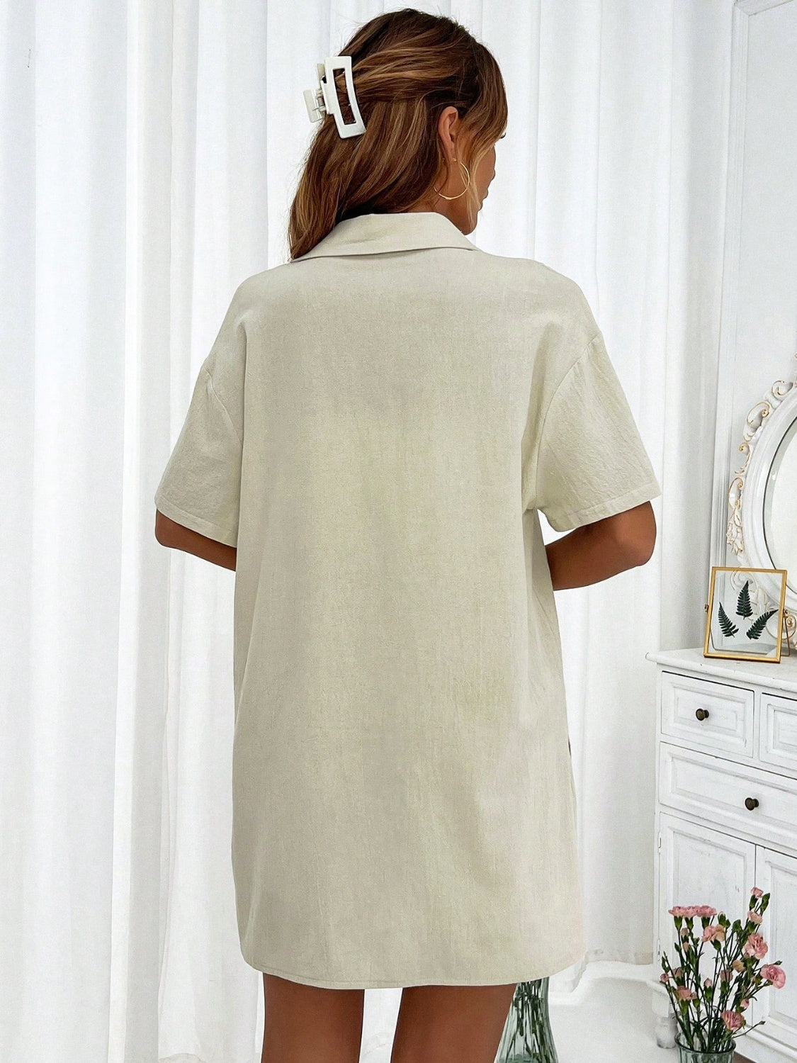 Linen resort shirt with short sleeves and collar, in a light beige color.