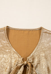 Gold Luxe Bow-Front Peplum Blouse with V-neck and tie detail.
