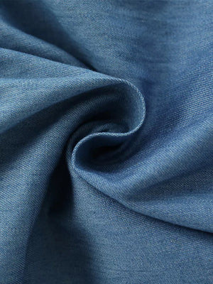 Blue denim fabric detail of a baby dress