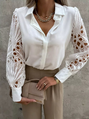White collared blouse with intricate lace sleeves and buttoned front.