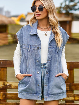 Oversized denim sleeveless jacket in dusty blue with button front and chest pockets.
