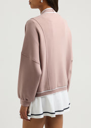 Dusty pink cocoon cardigan with varsity trim and button detail.