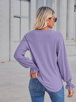 Periwinkle eyelet blouse with ruffled cuffs and long sleeves.