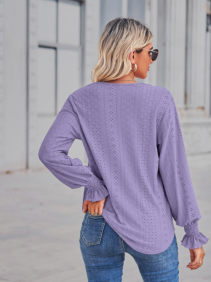 Periwinkle eyelet blouse with ruffled cuffs and long sleeves.