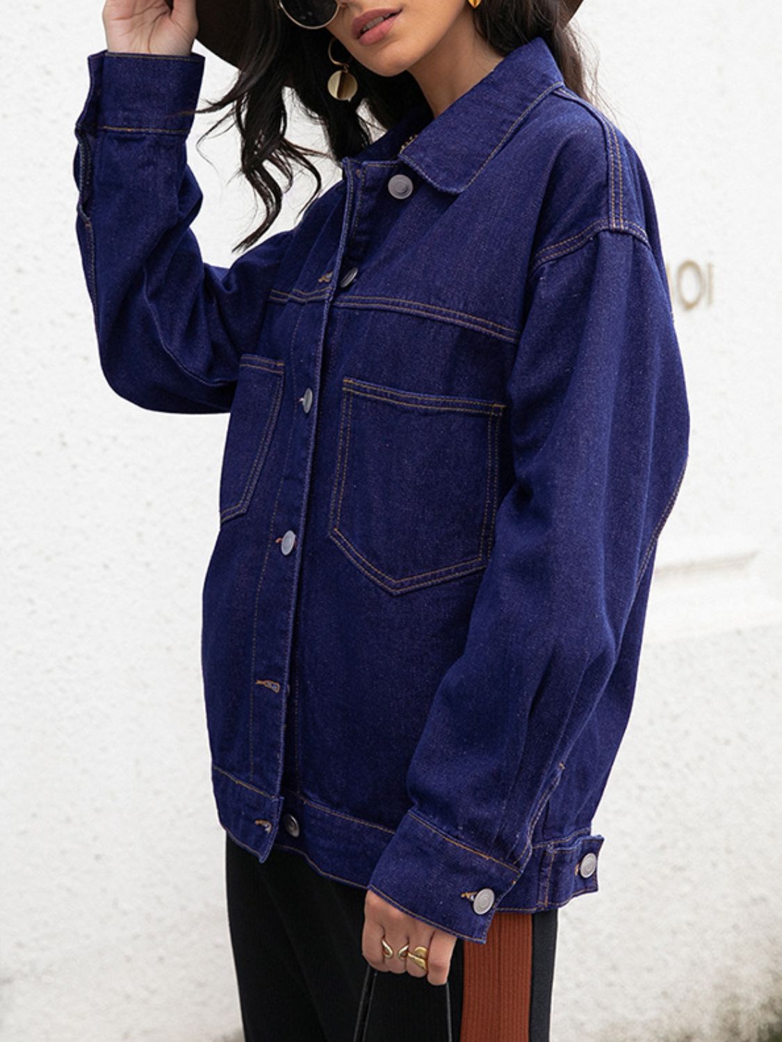 Dark oversized denim trucker jacket with contrast stitching and buttoned front.