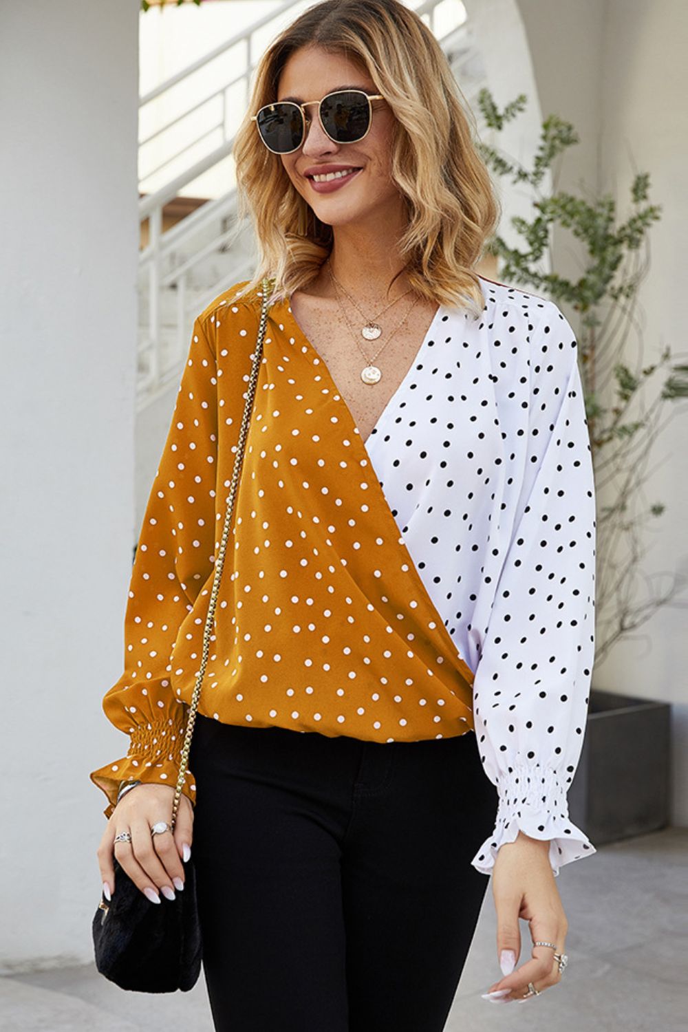 Colorblock polka dot wrap blouse in tangerine and white with ruffled cuffs.