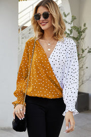 Colorblock polka dot wrap blouse in tangerine and white with ruffled cuffs.