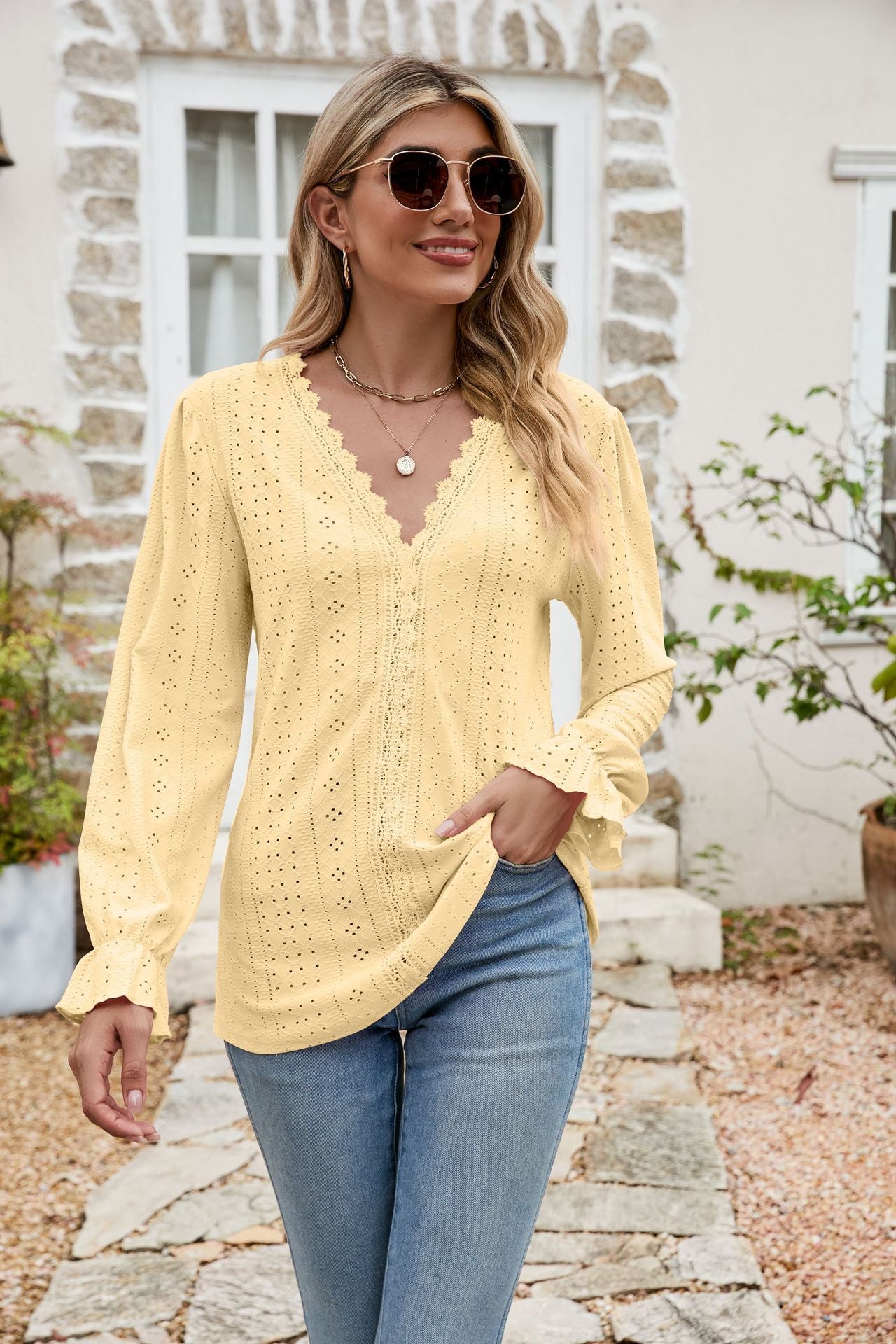 Light yellow eyelet lace blouse with ruffle sleeves and V-neckline.