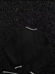 Black bomber jacket with white striped collar, cuffs, and hem