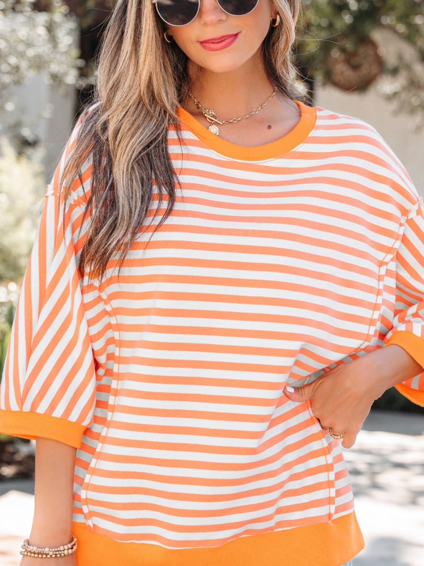 Oversized orange and white striped cotton t-shirt with 3/4 sleeves and crew neck.