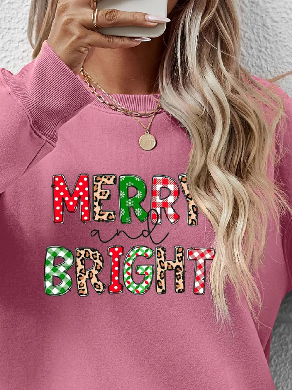 Blush Pink sweatshirt with "Merry and Bright" graphic in festive patterns and leopard print.