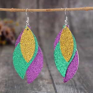 Glittering layered leaf statement earrings in gold, green, and purple.