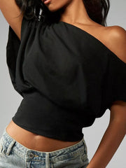 Black asymmetrical crop t-shirt with draped fit and one-shoulder neckline.