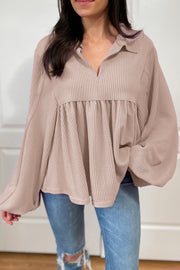 Beige textured blouse with gathered yoke, collar, and balloon sleeves.