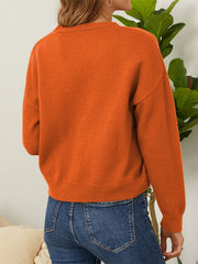 Orange V-neck cardigan with ribbed cuffs and hem, detailed view from back.