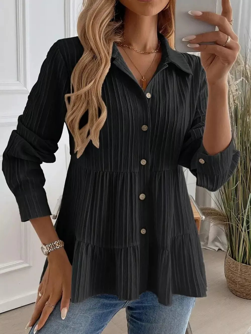 Black textured tiered button-down shirt with crinkled fabric and button details.