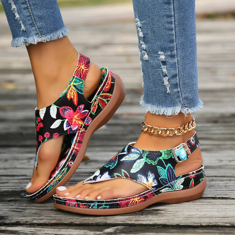 Embroidered floral thong wedge sandals with adjustable ankle strap and buckle.