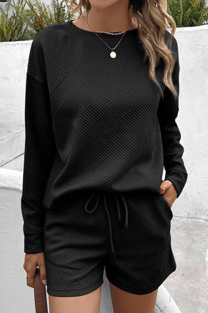 Black textured geometric loungewear set with crewneck sweatshirt and drawstring shorts.