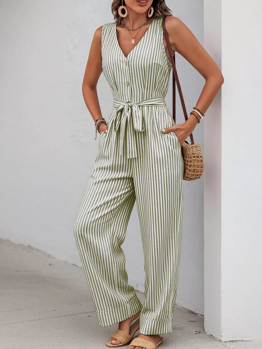 Striped tie-waist wide leg romper in yellow-green with decorative buttons and V-neck.