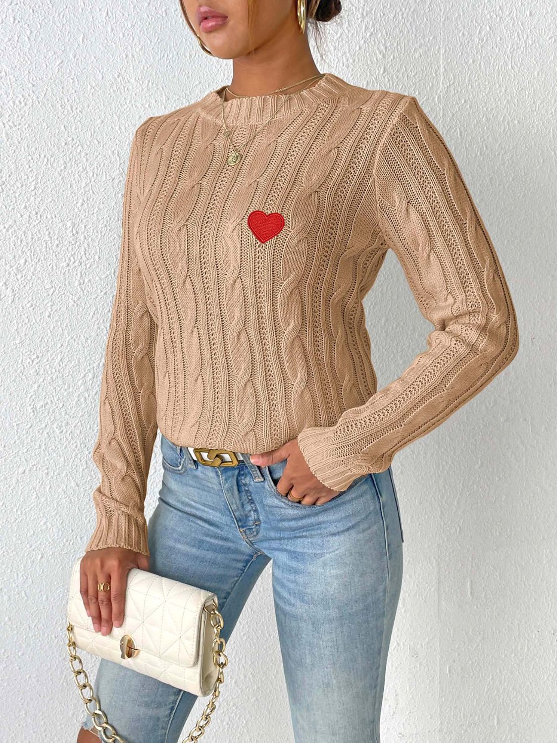 Camel cable knit sweater with embroidered red heart detail.