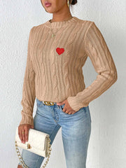 Camel cable knit sweater with embroidered red heart detail.
