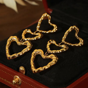Gold triple heart drop earrings with textured detail