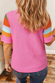 Geometric stripe openwork knit top in multicolor with short sleeves and a round neckline.