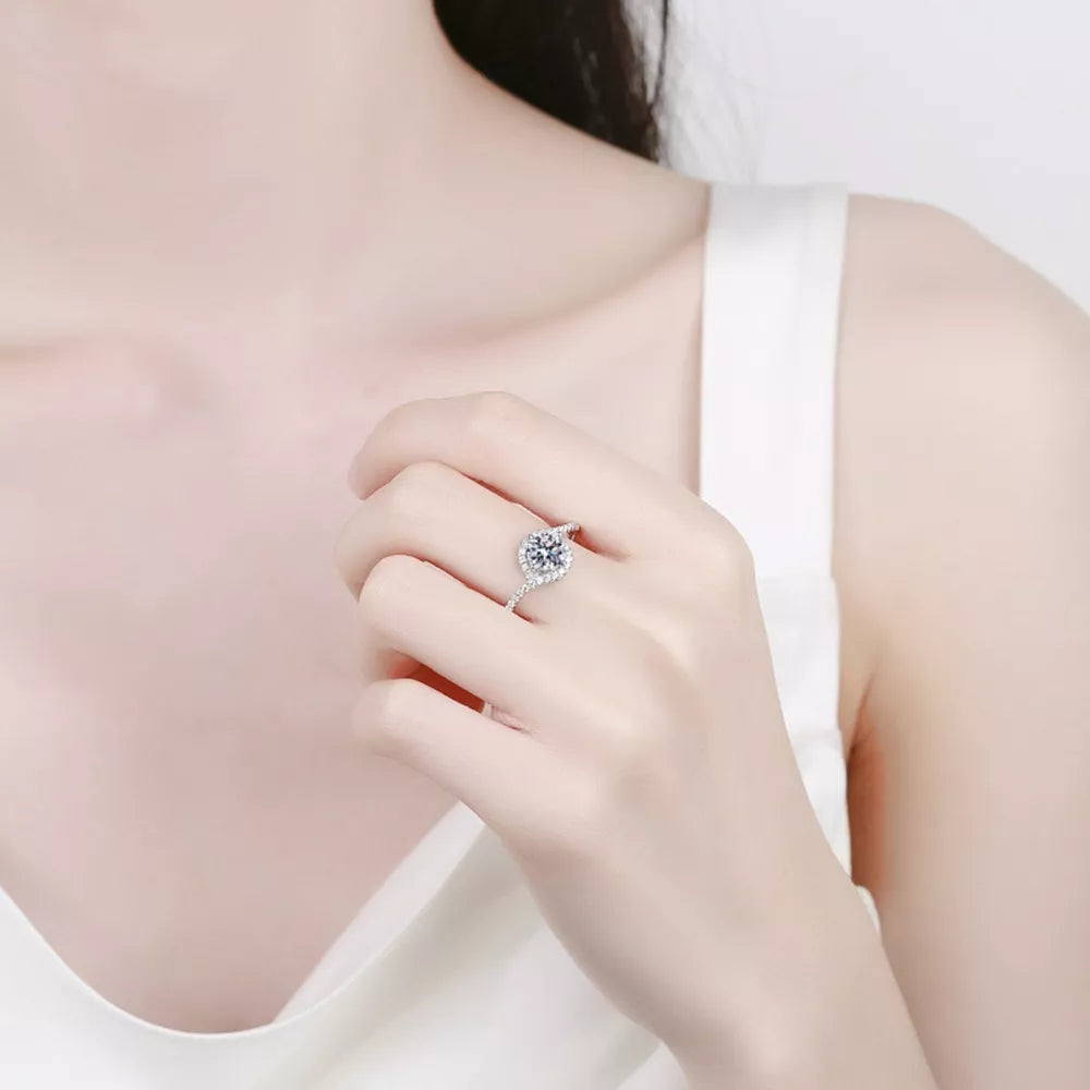Dazzling Moissanite Halo Ring in silver with a round center stone and sparkling accent stones.