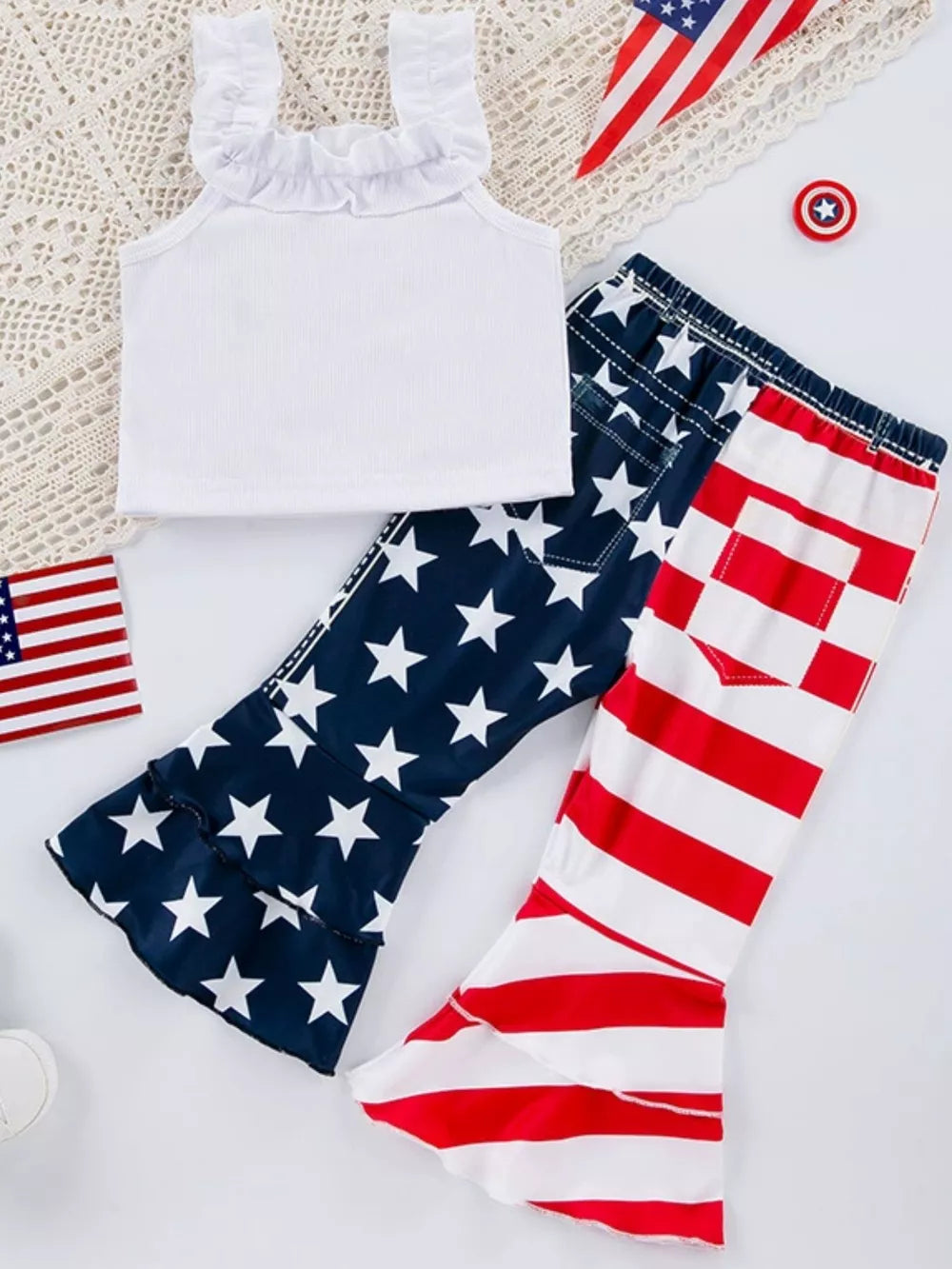 White ruffle tank top with patriotic star print and striped bell bottom pants.
