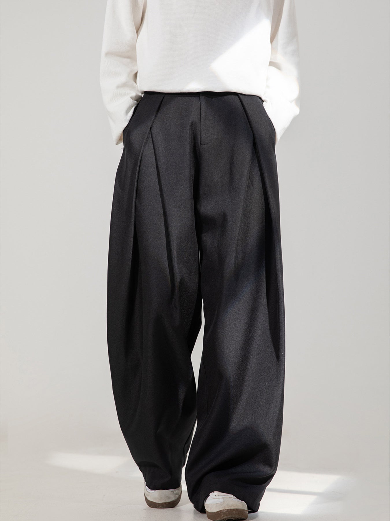 Men's black wide-leg trousers with pleats and pockets.