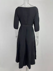 Black off-the-shoulder belted midi dress with 3/4 sleeves and a flared skirt.