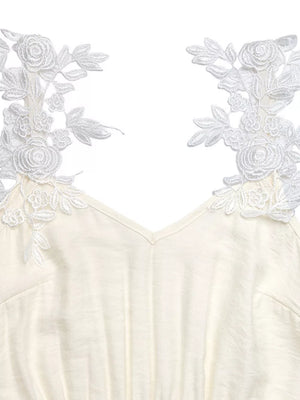 Beige V-neck maxi dress with delicate white lace floral trim on the shoulders.
