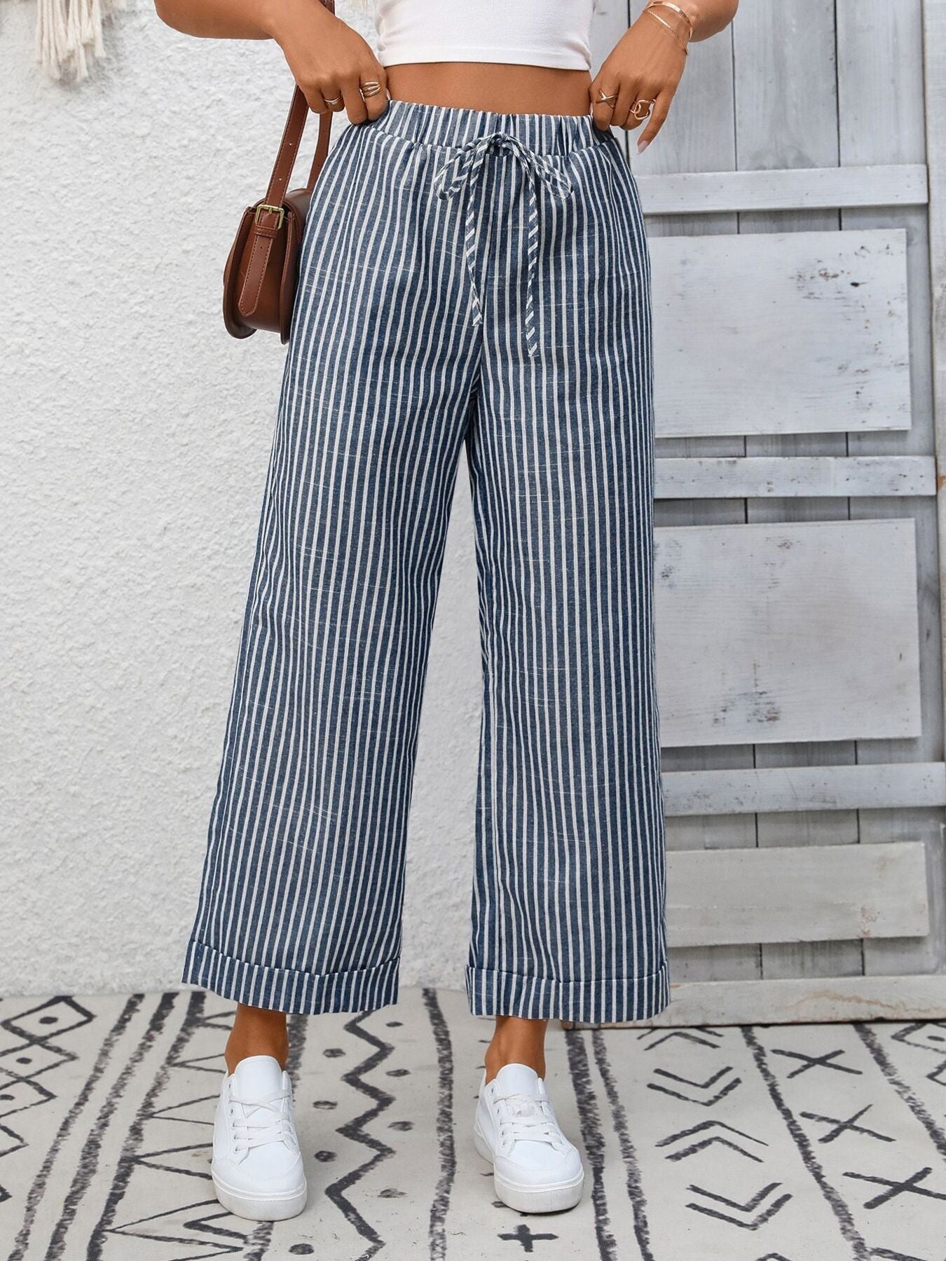 Navy blue striped wide leg pants with drawstring waist and pockets, cuffed hem.