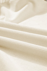 Textured eggshell corduroy blouse with ruffle sleeves.
