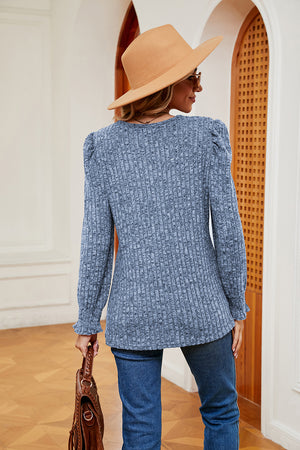 Textured pastel blue knit blouse with square neckline and cuffed sleeves.