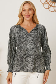 Black serpentine print blouse with gathered sleeves and V-neckline.