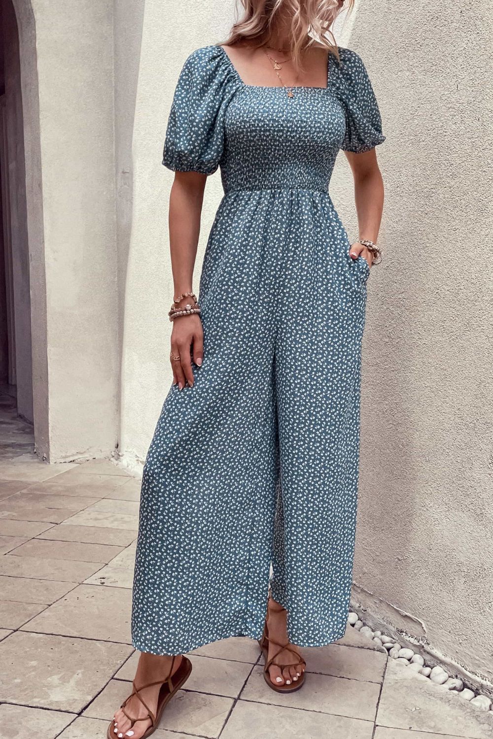 Cerulean floral print square neck jumpsuit with puff sleeves and wide legs.
