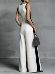 White wide-leg jumpsuit with black contrast trim and deep v-neck.