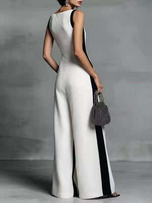 White wide-leg jumpsuit with black contrast trim and deep v-neck.