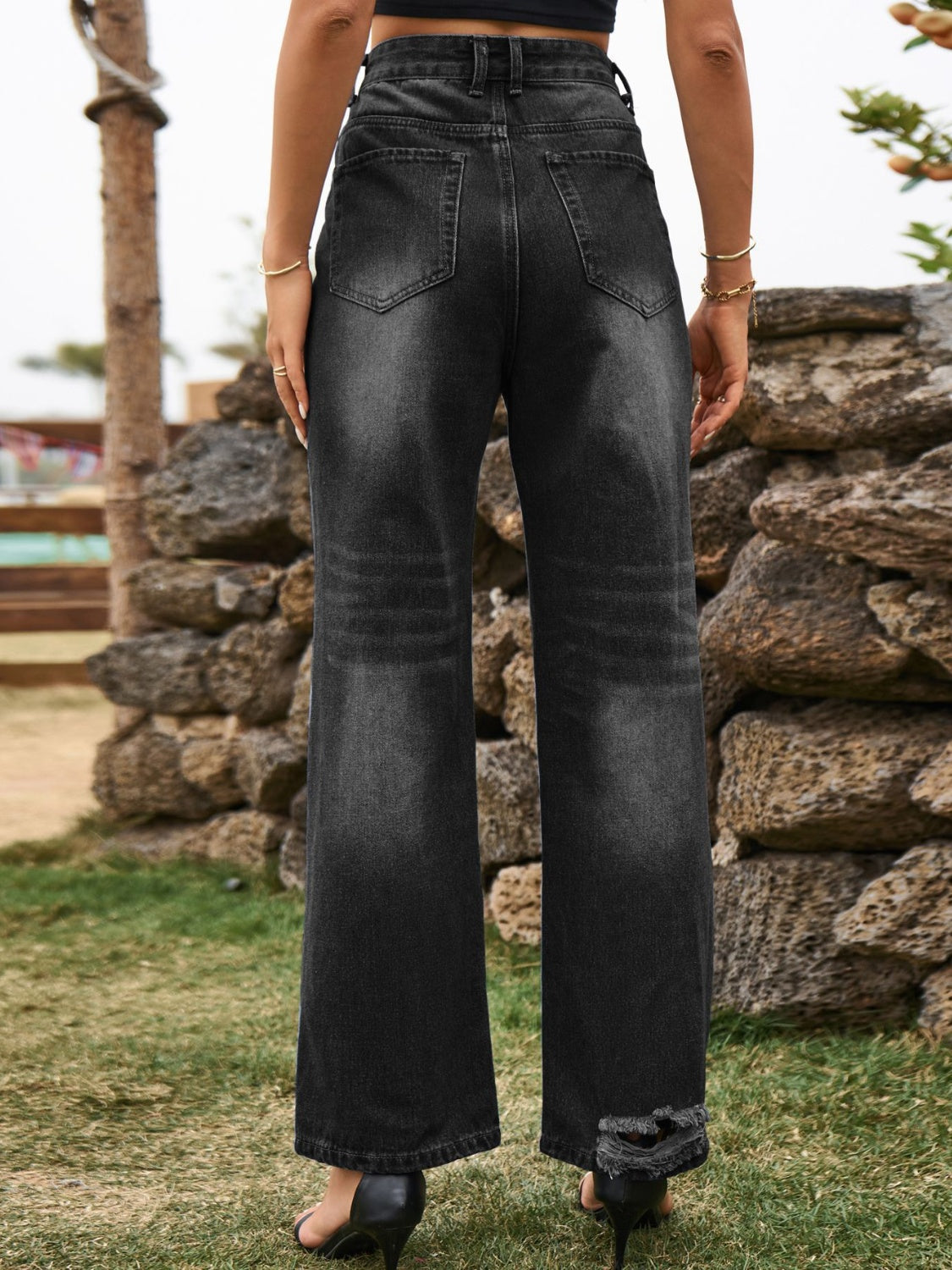 Distressed black flare denim jeans with frayed hem detail.
