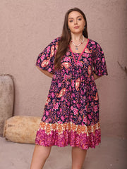 Plus-size floral flutter dress with ruched bodice and tiered border hem.