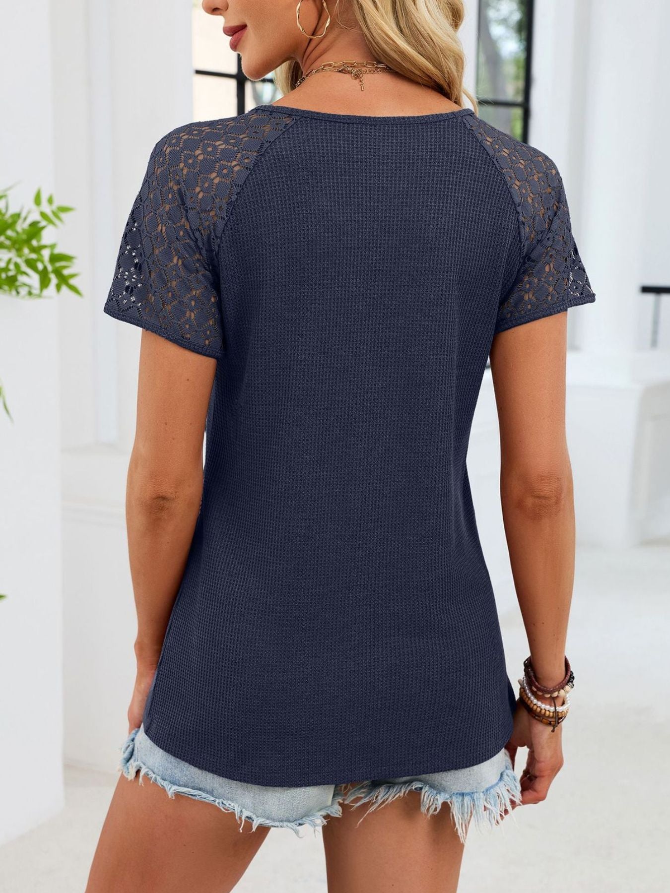 Navy blue waffle knit t-shirt with lace short sleeves and V-neck.