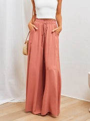 Coral wide-leg palazzo pants with gathered waist and drawstring detail.