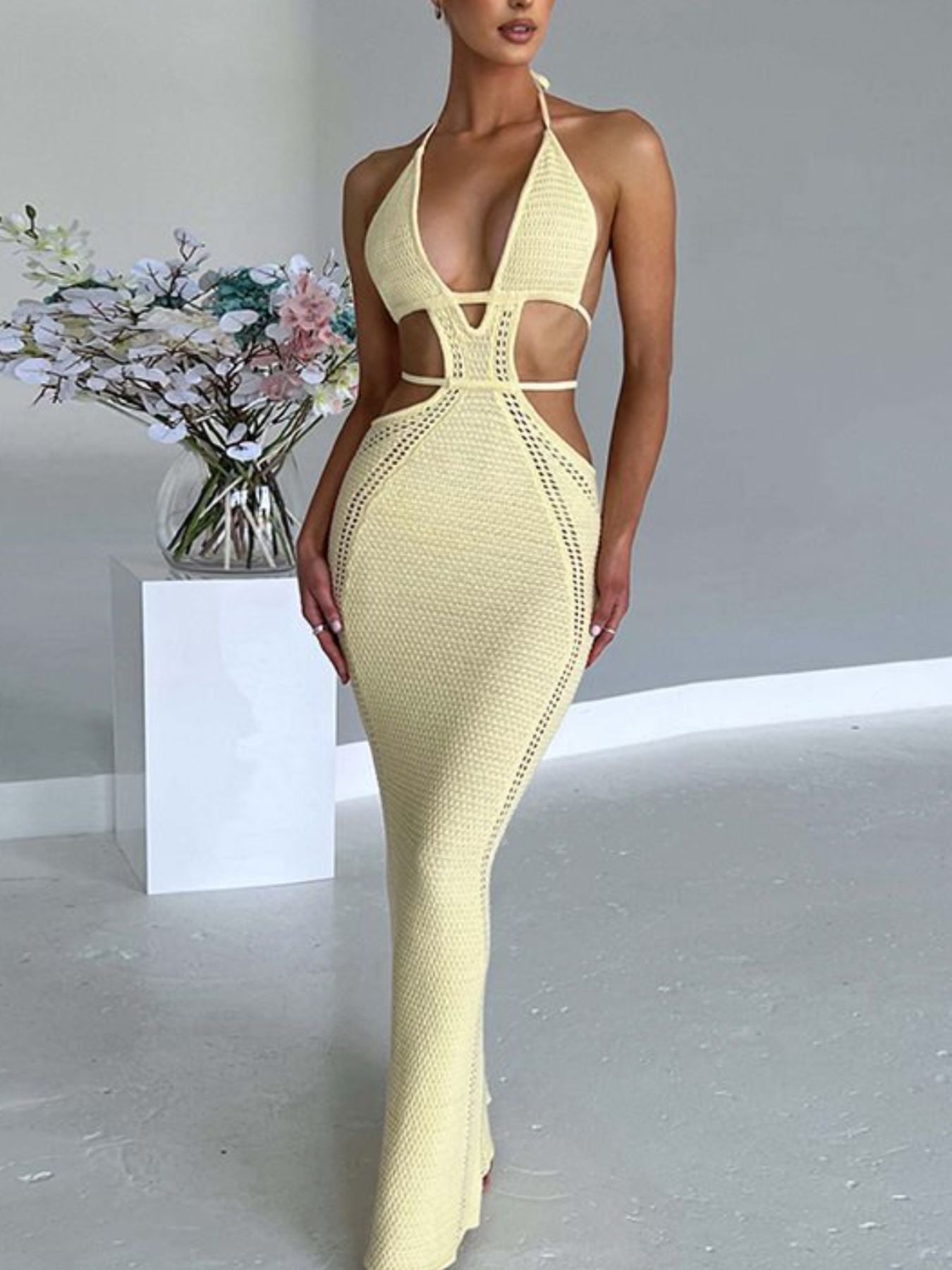 Pastel yellow knitted maxi dress with deep v-neck and cutouts