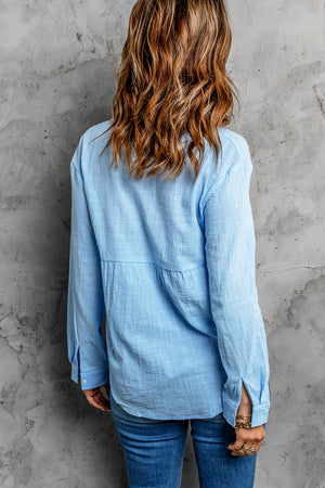 Light blue textured cotton relaxed fit shirt with button cuffs and a tiered bodice detail.