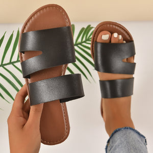 Chic black open toe flat sandals with double strap detail.