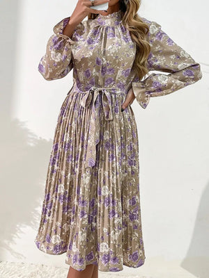 Elegant floral midi dress in khaki with purple roses, featuring a tie waist and pleated skirt.