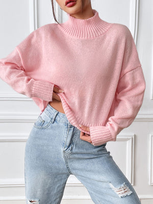 Cropped ribbed turtleneck knit sweater in blush pink with cuffed sleeves and hem.