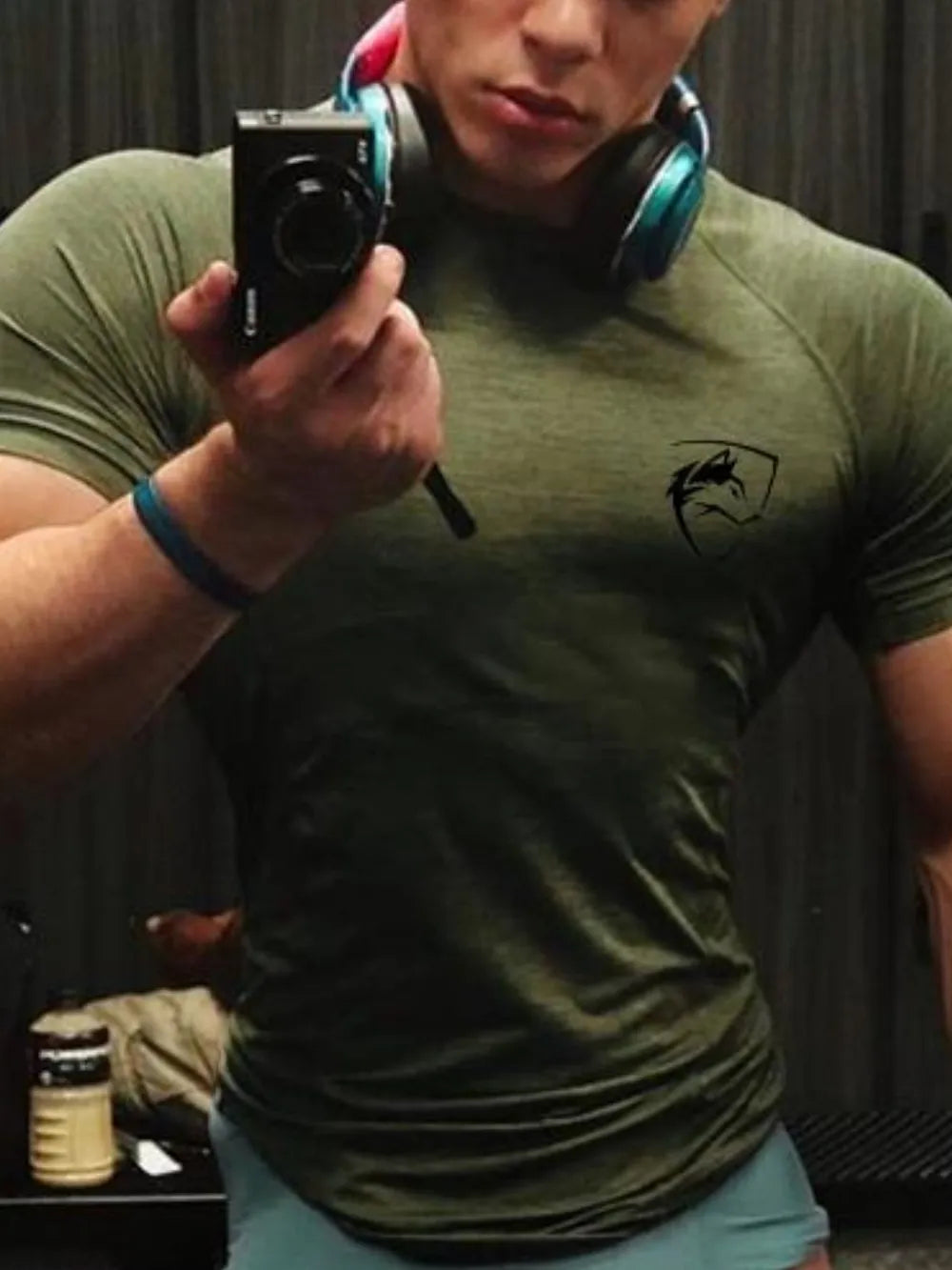 Performance raglan tee in Army Green with a black emblem on the chest.
